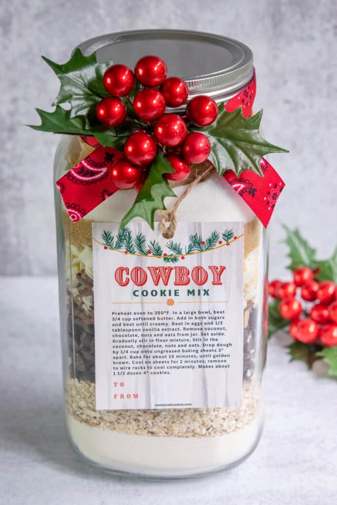 Mason jar filled with cowboy cookie mix with a christmas gift tag and baking instructions for cookies.