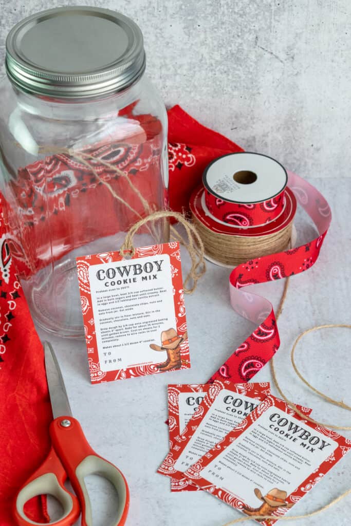 Western, bandana themed cowboy cookie mix gift tags and rolls of ribbon and twine for decorating the mason jar.