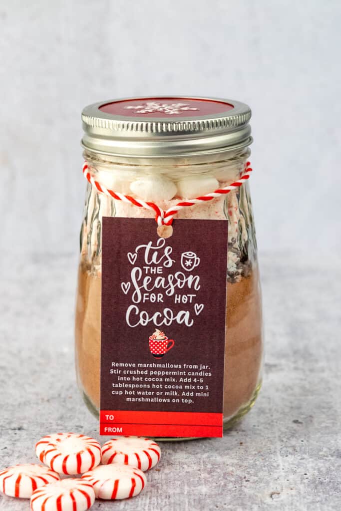 Homemade Hot Chocolate Mix in a jar with gift tag and peppermint candy.