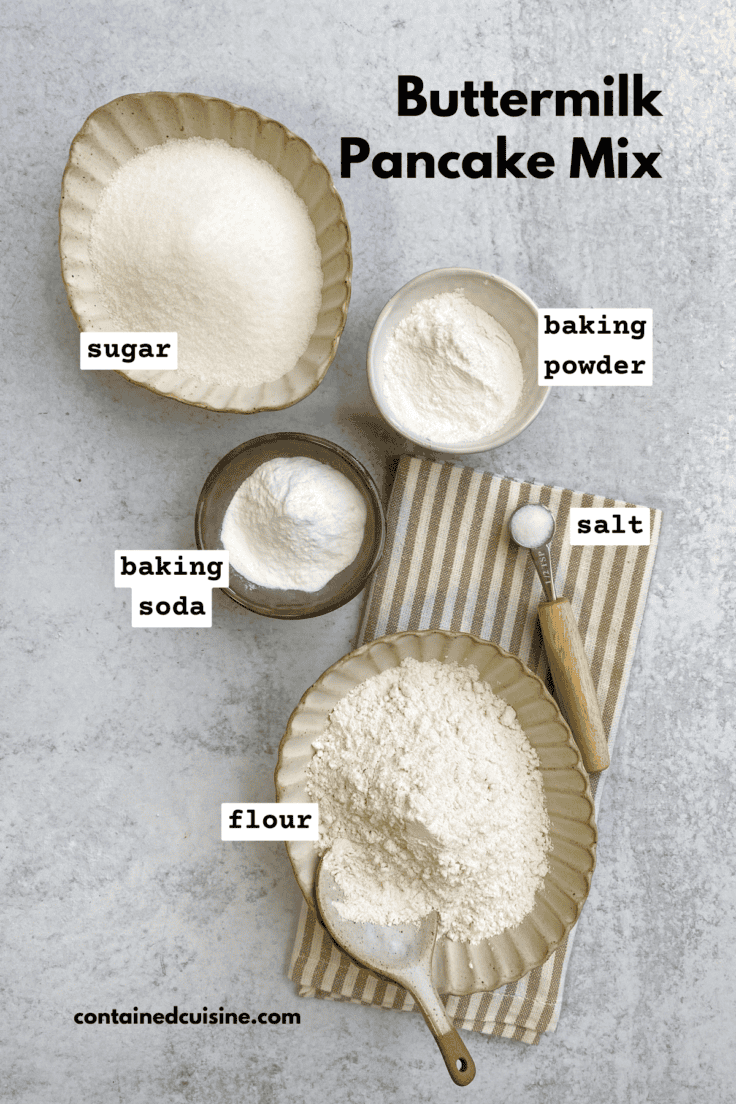 All the dry ingredients needed to make homemade buttermilk pancake mix in small bowls, including flour, sugar, salt, baking powder and baking soda.