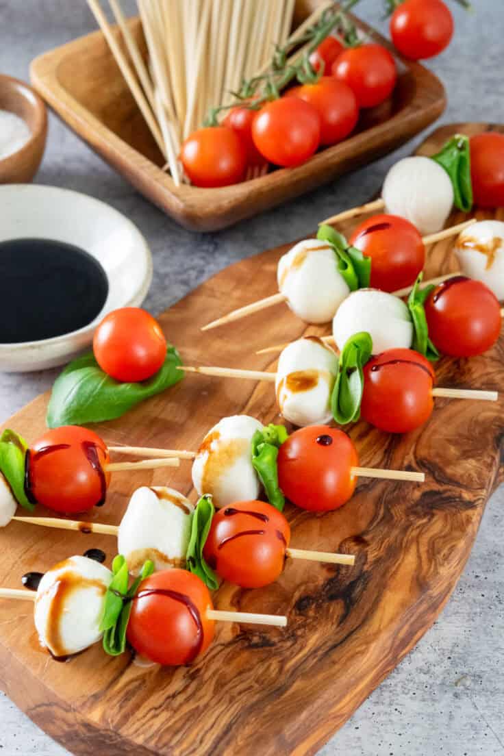 Wooden board with caprese skewers ready for serving at a party.