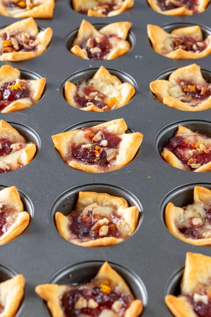 Mini muffin tin filled with baked crescent brie bites.