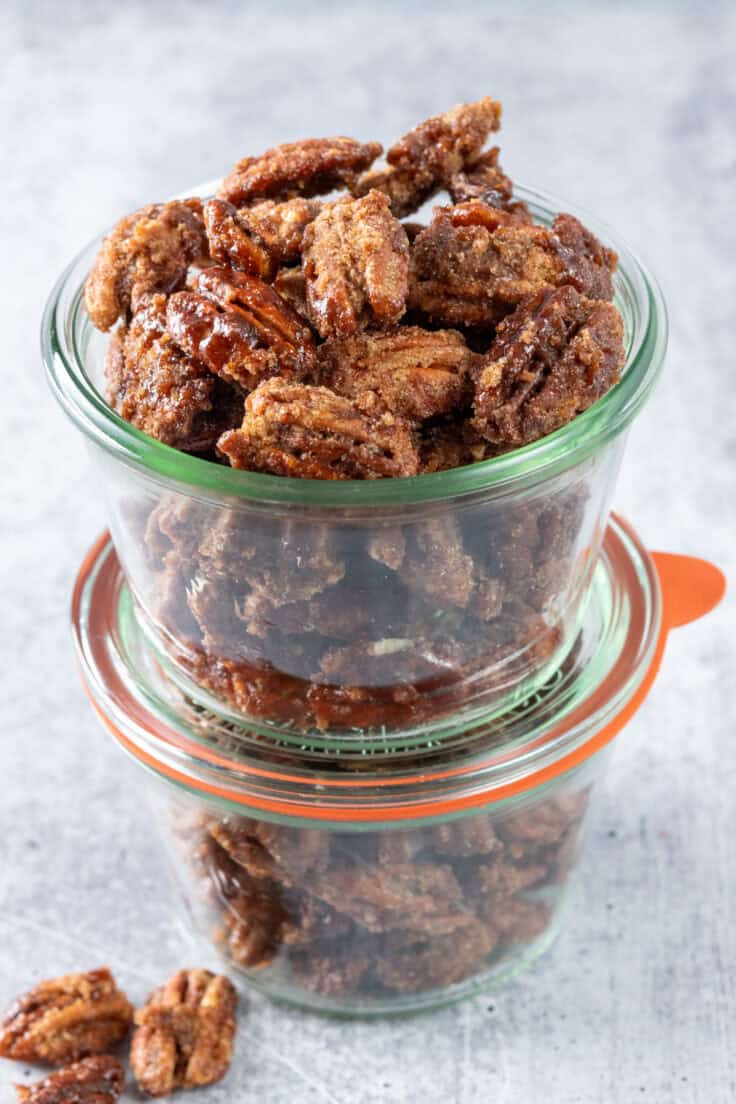 Two Weck jars stacked on top of each other full of candied pecans to give as gifts.