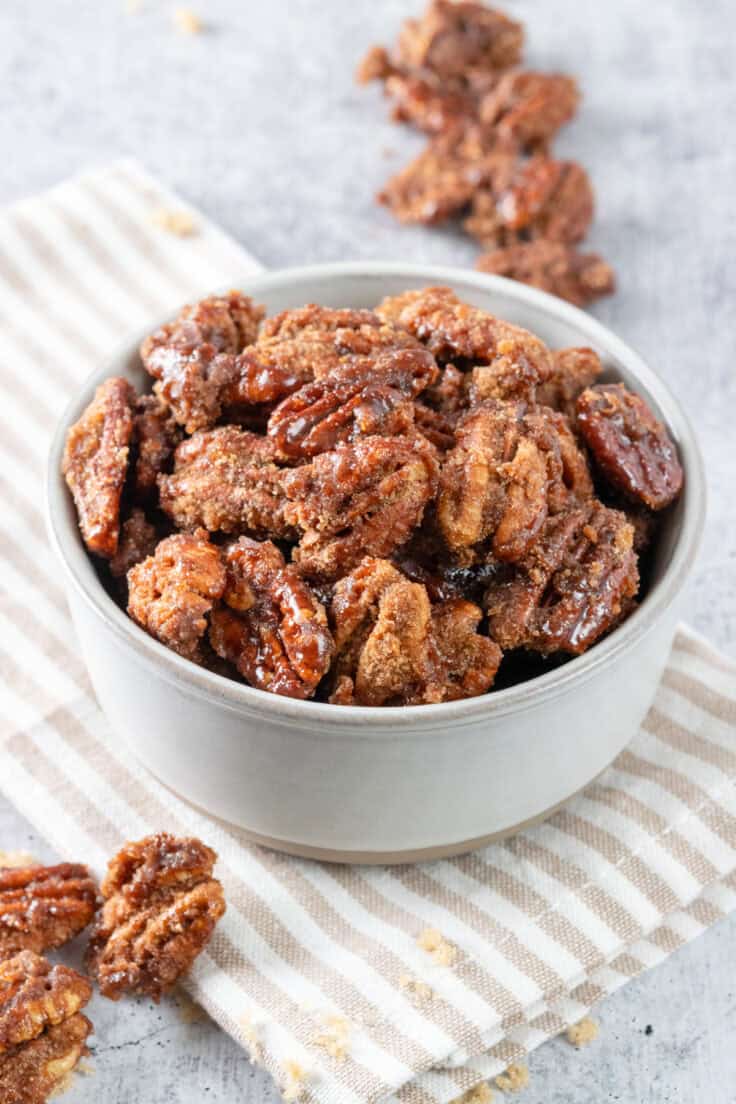 A ceramic bowl full of the candied nuts showing their crunchy, cinnamon sugar coating.