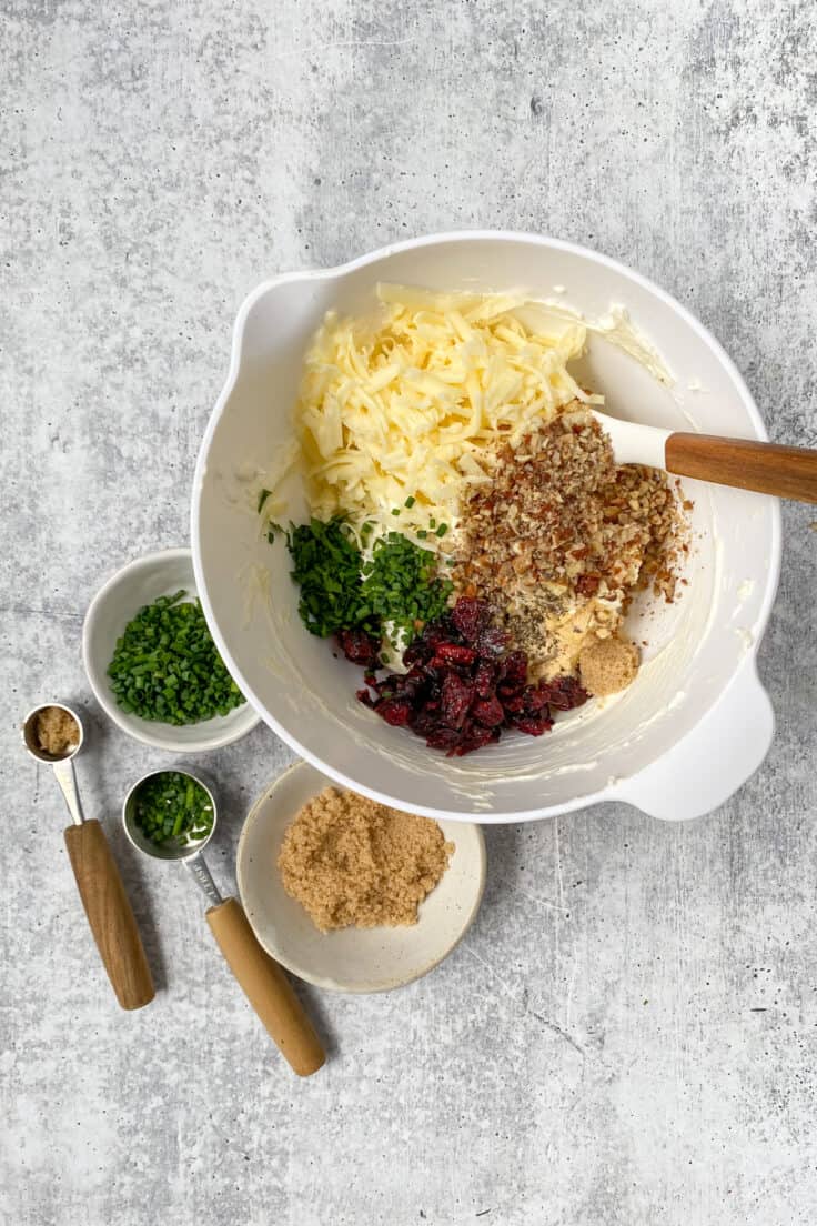 White cheddar, chopped pecans, cranberries, parsley, chives and seasonings added to bowl with the beaten cream cheese.