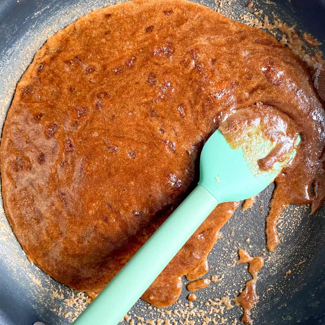 Hot cinnamon sugar glaze in skillet with bubbles all over.