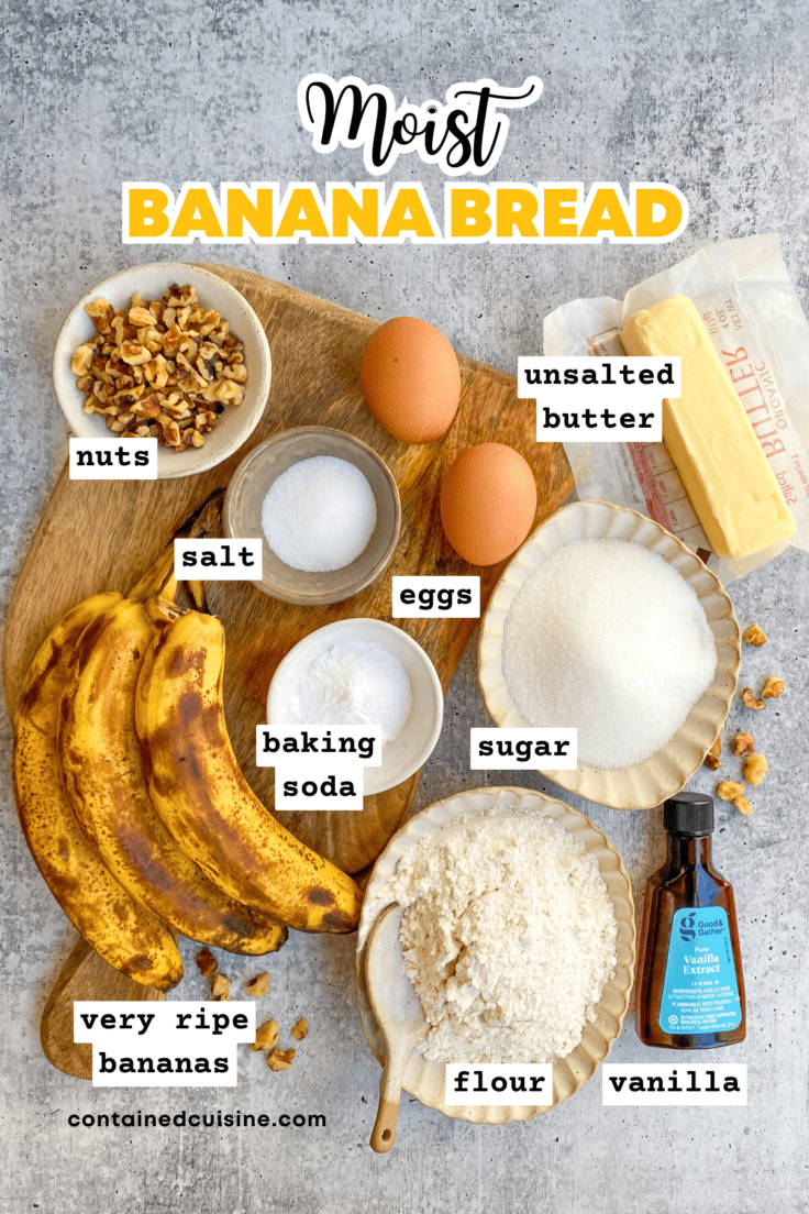 Overhead picture showing ingredients needed to make banana bread spread out in small bowls on a wood cutting board, including three over-ripe bananas.