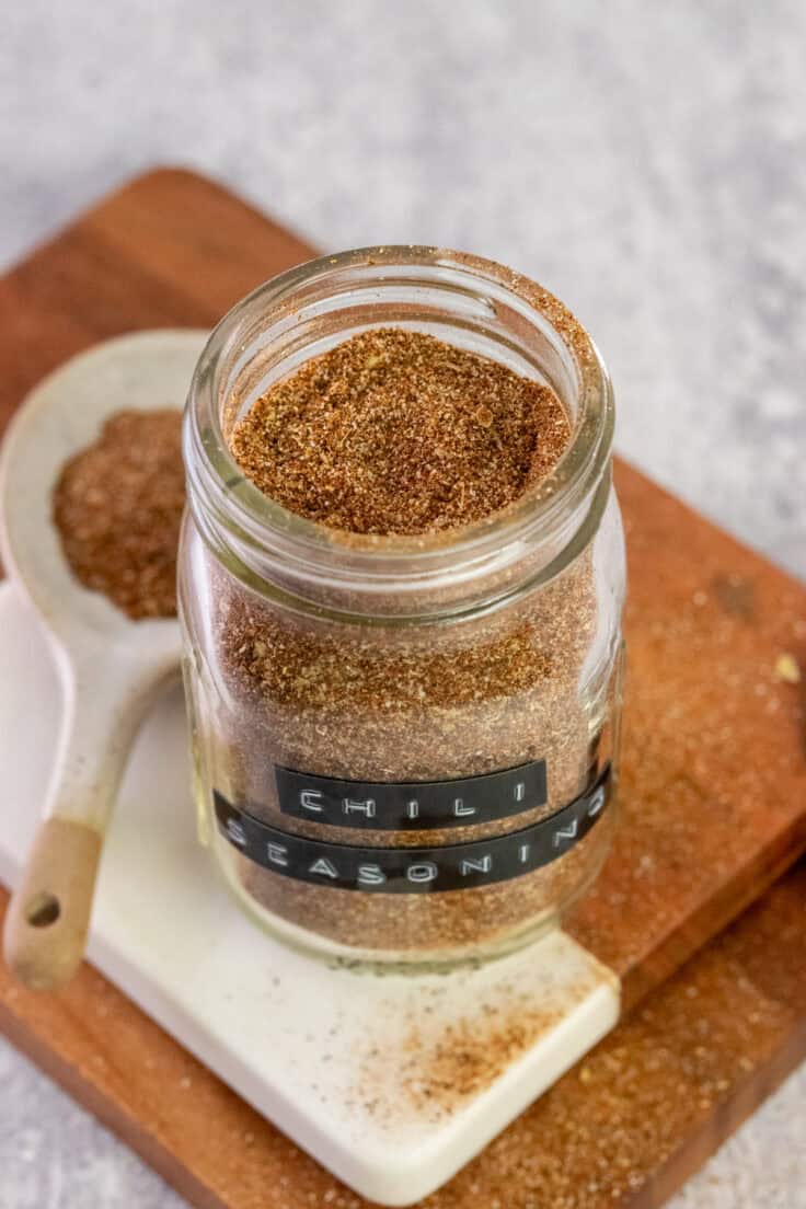 Homemade chili seasoning mix in a small mason jar without a lid on top, showing the blend of Mexican spices.