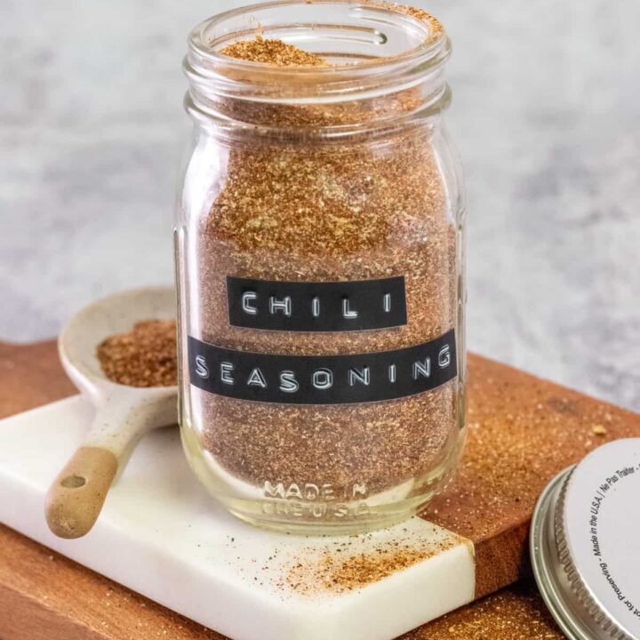 Homemade chili seasoning mix in a glass jar with a black label on it that says, chili seasoning.