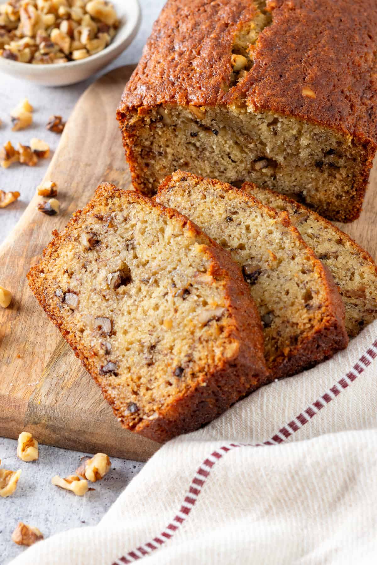 A loaf of homemade banana bread and banana bread slices showing how moist it is.