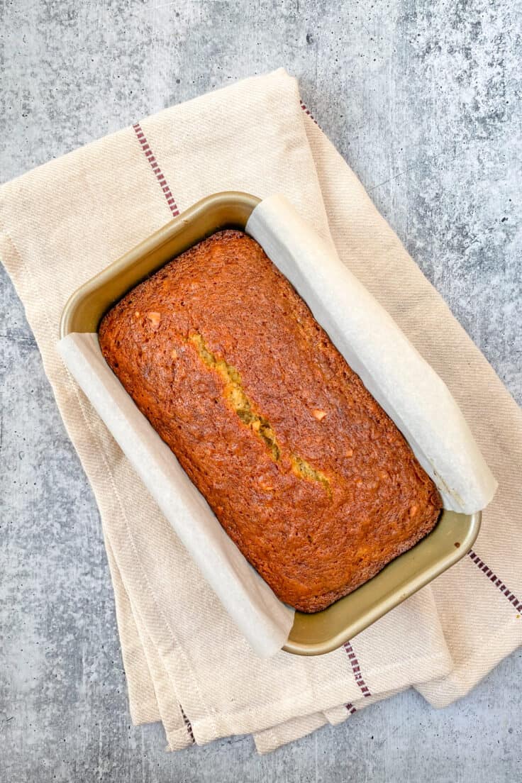 Baked banana bread just out of the oven cooling in the loaf pan for a few minutes.