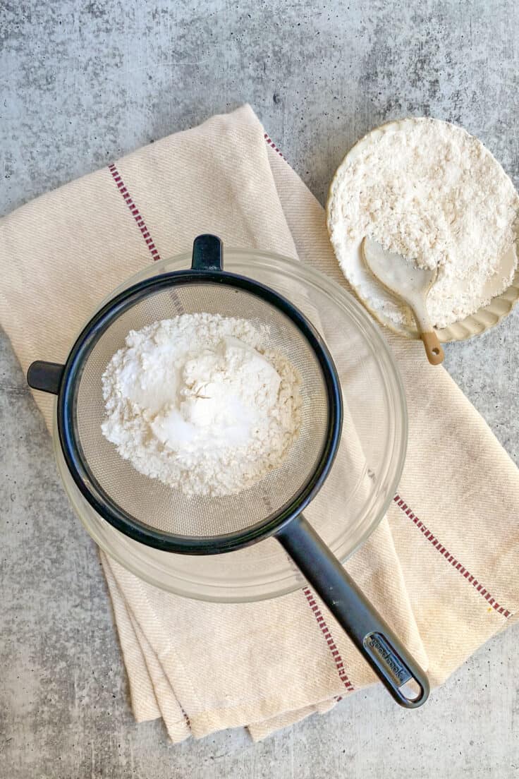 Flour being sifted into a small bowl.