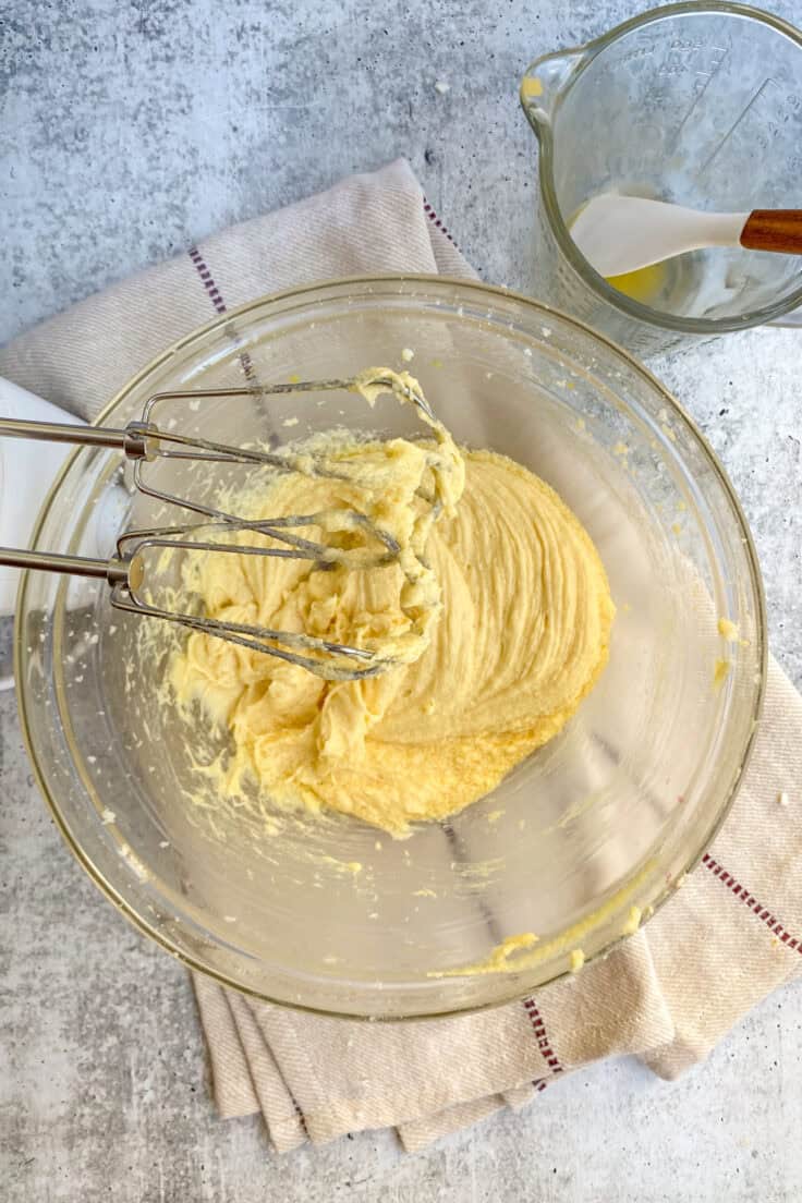 Creamed butter and sugar in a mixing bowl with electric mixer beaters in it.