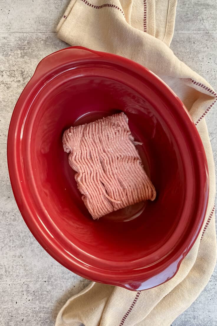 Uncooked ground turkey in a Crock Pot.