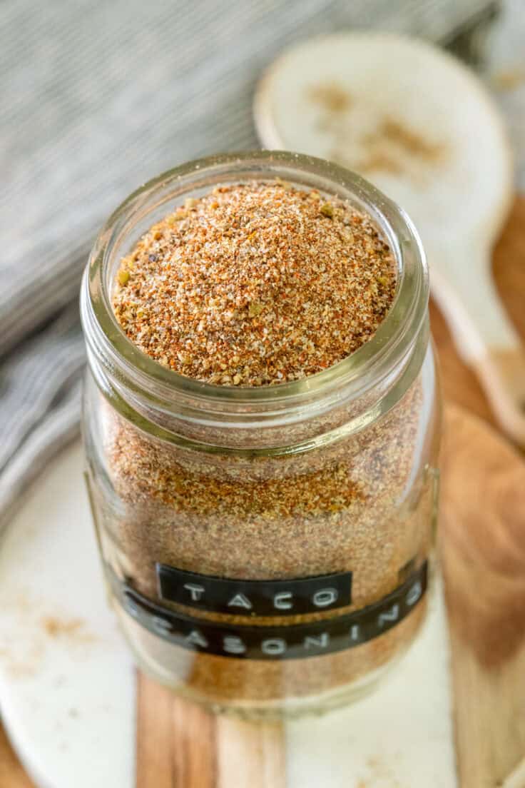 Close up picture of an opened spice jar full of taco seasoning that shows the colorful blend of spices.