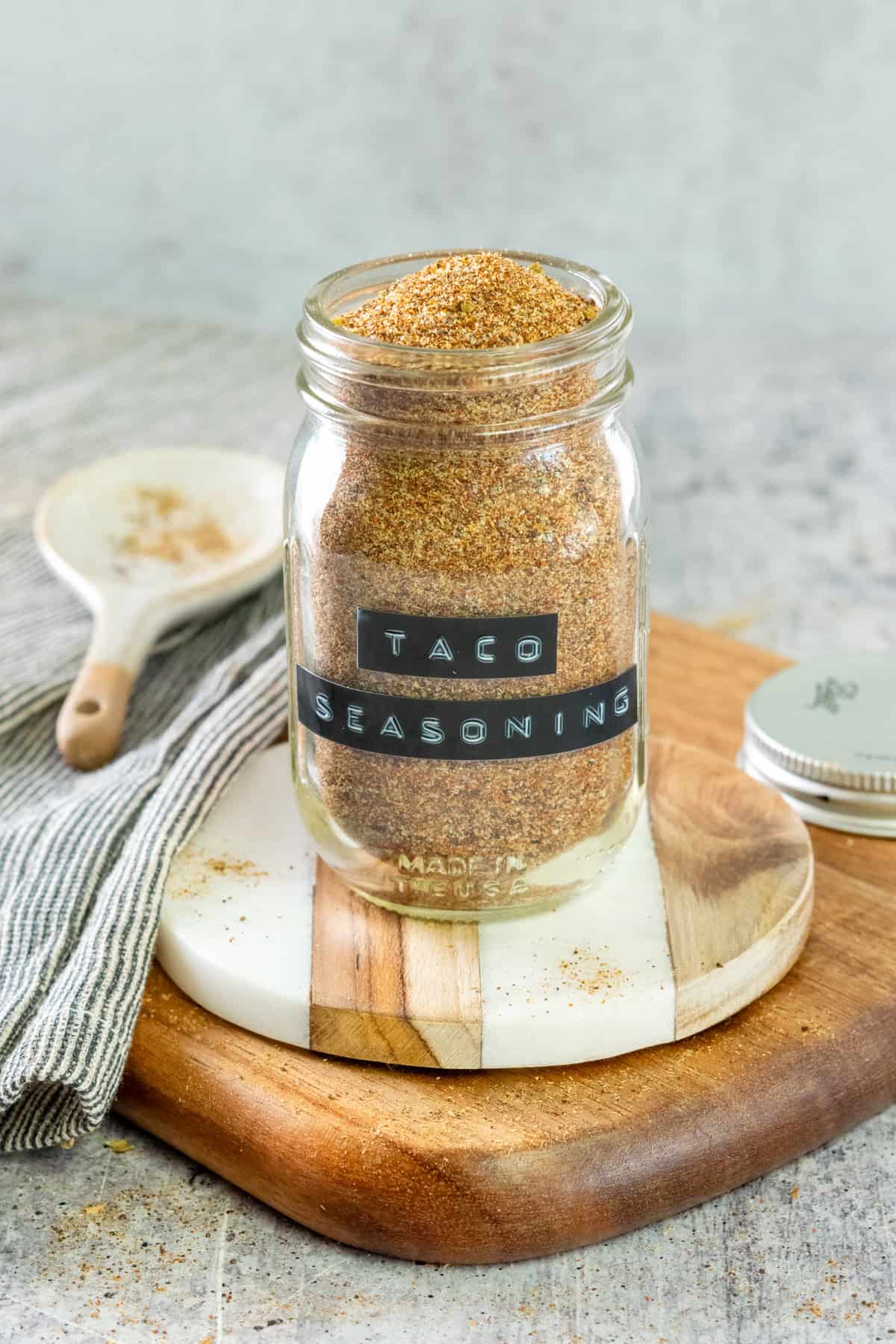 Jar of homemade taco seasoning with a label on the spice jar that says, taco seasoning.