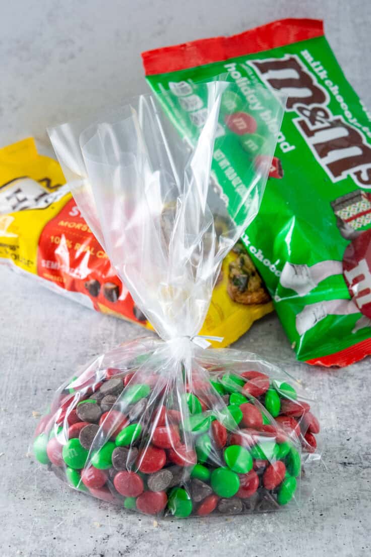 Mixture of holiday m&m's and chocolate chips in a clear cellophane bag with twist tie.