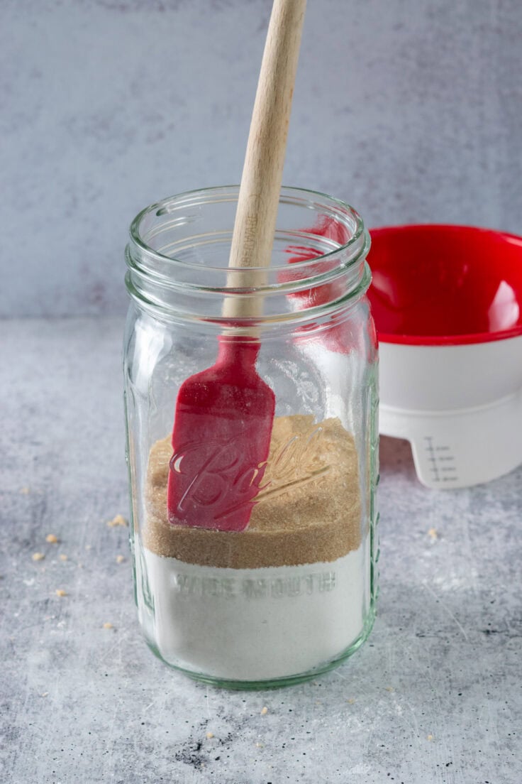 The brown sugar layer of the cookie mix in a jar that's packed down and leveled.