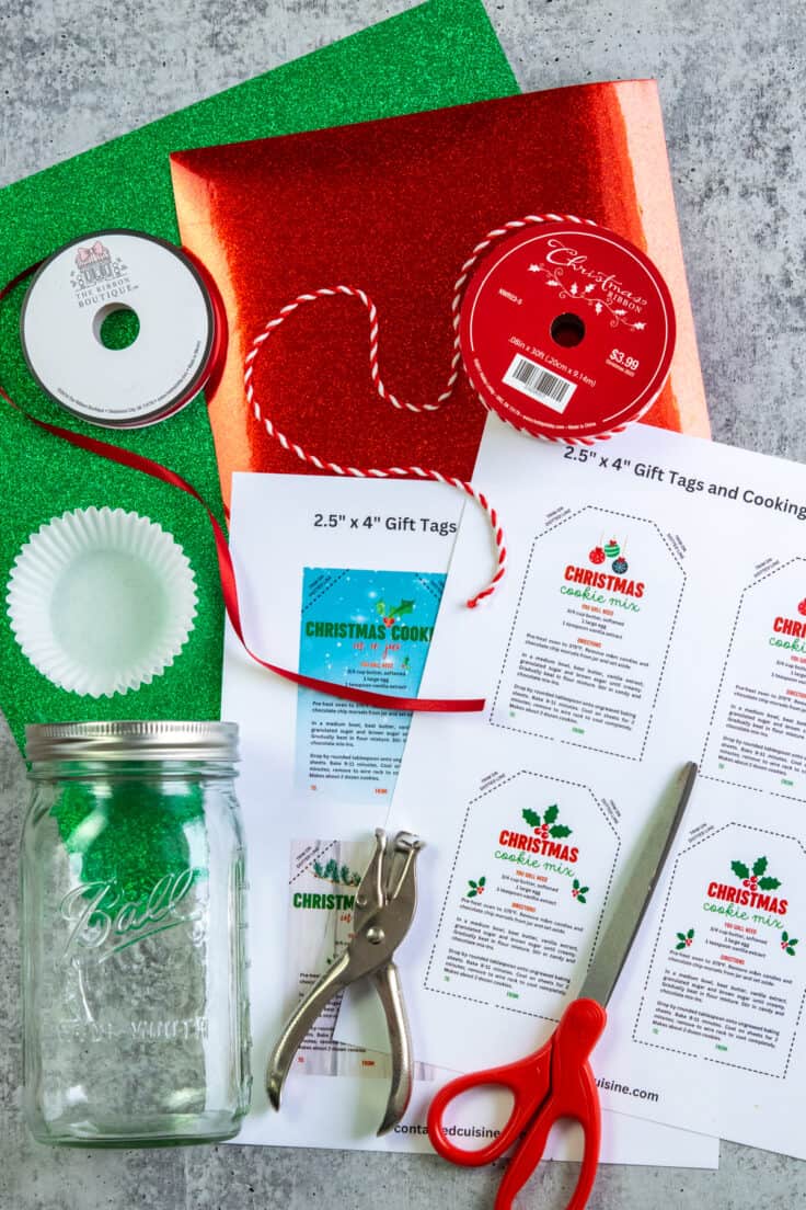 Red and green paper, Christmas ribbon, a mason jar, scissors and printed Christmas cookie mix gift tags.