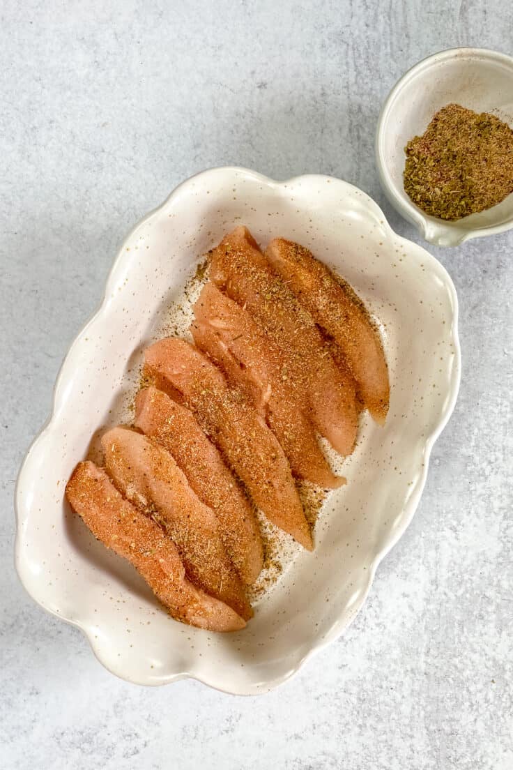 Raw chicken tenders generously coated in a dry rub.