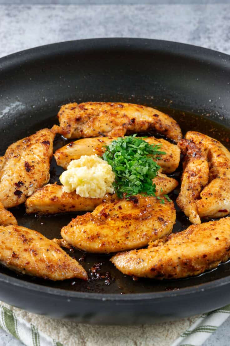 Honey. minced garlic and finely chopped parsley on top of the chicken in the skillet.