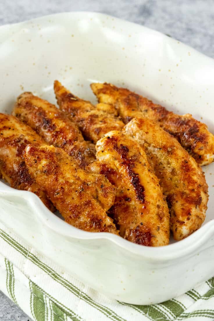 Cooked chicken tenderloins in a serving dish.