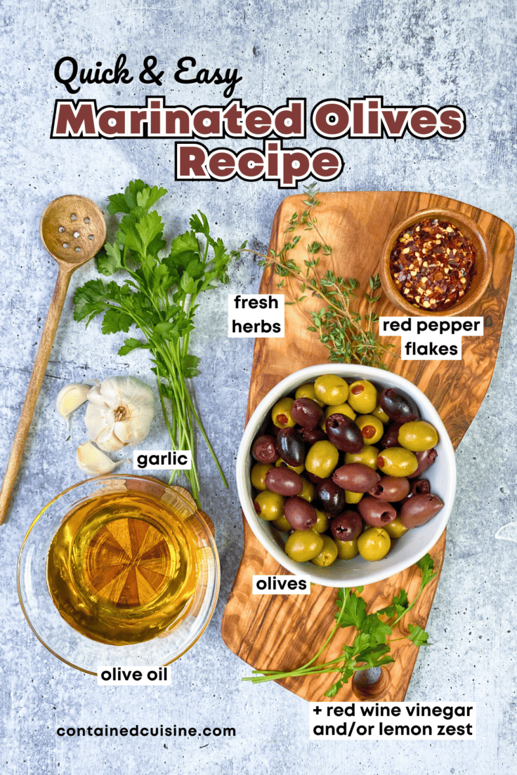 An overhead picture showing a wooden olive spoon with holes, some fresh parsley and thyme, a bulb of garlic, and small bowls with the rest of the ingredients needed to make marinated olives. There's a bowl of red pepper flakes, a bowl of olive oil and a bowl containing a combination of black and green olives.