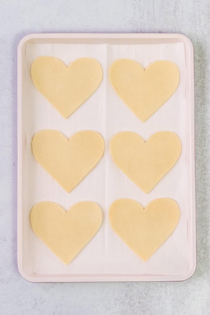 Heart-shaped pie crusts on a baking tray.