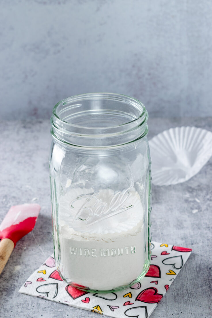 Flour in the bottom of a mason jar to make a cookie mix gift.