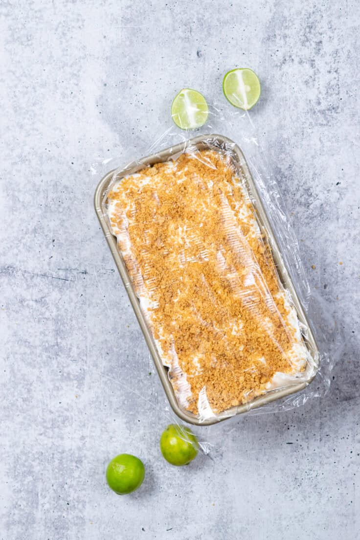 Plastic wrap is covering the homemade key lime pie ice cream and is ready to be placed in the freezer overnight.