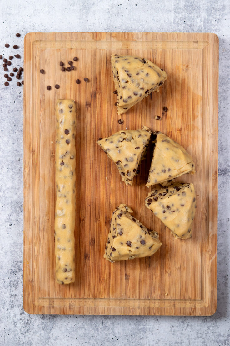 Cookie dough on a cutting board divided into six equal portions.