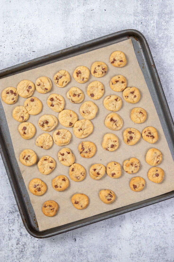 A baking sheet filled with the baked mini bite-sized cookies.