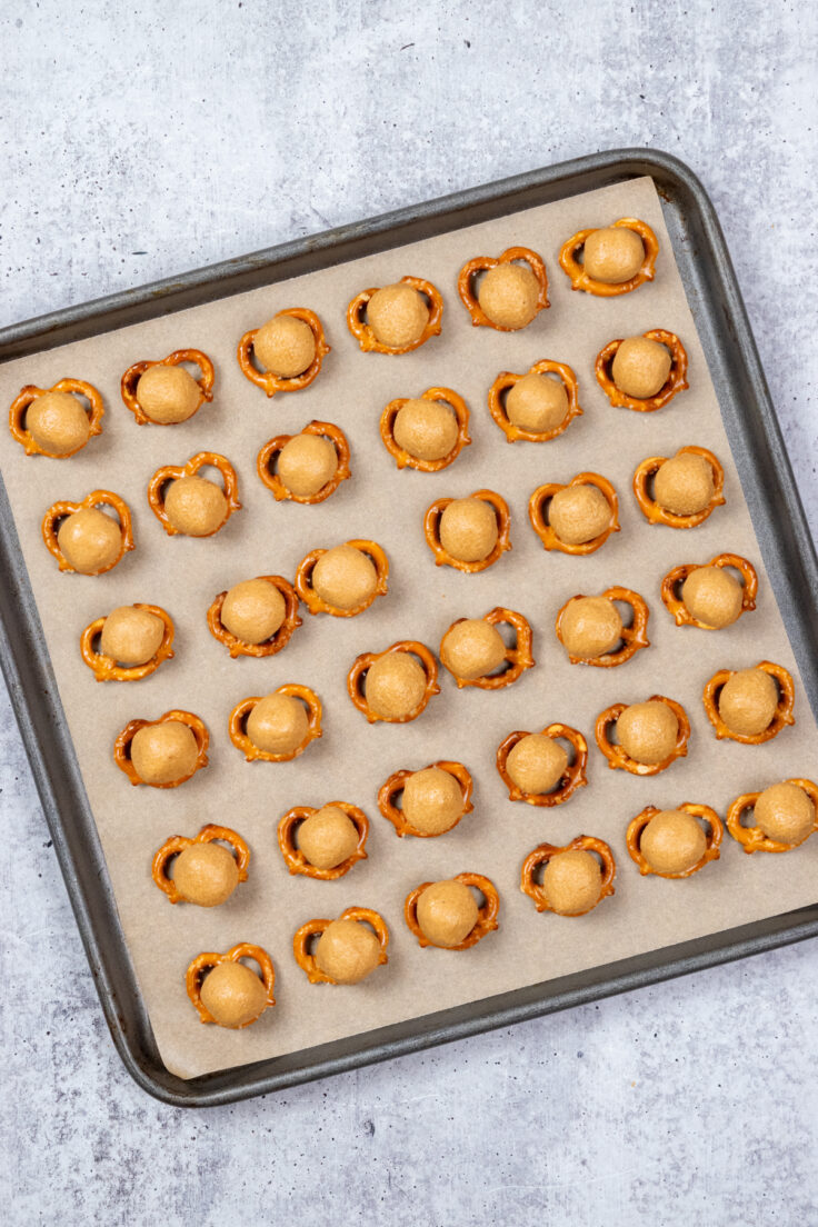 A ball of peanut butter on top of each pretzel.