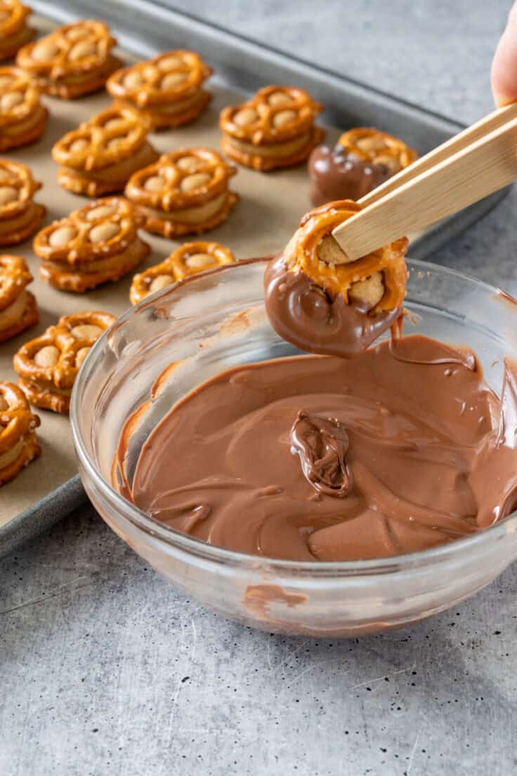 Dipping a bite halfway in chocolate.