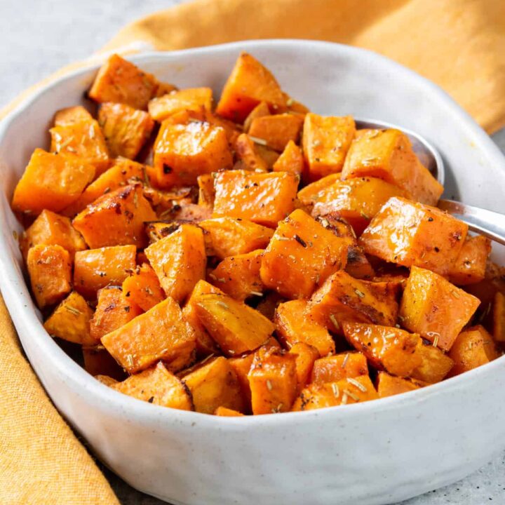 Roasted sweet potatoes in a serving dish. The potatoes are cubed and roasted.