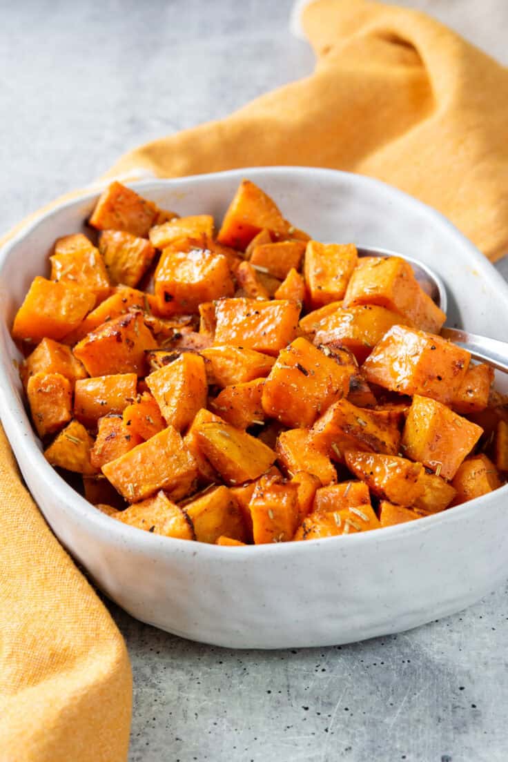 Roasted sweet potatoes in a serving dish. The potatoes are cubed and roasted.