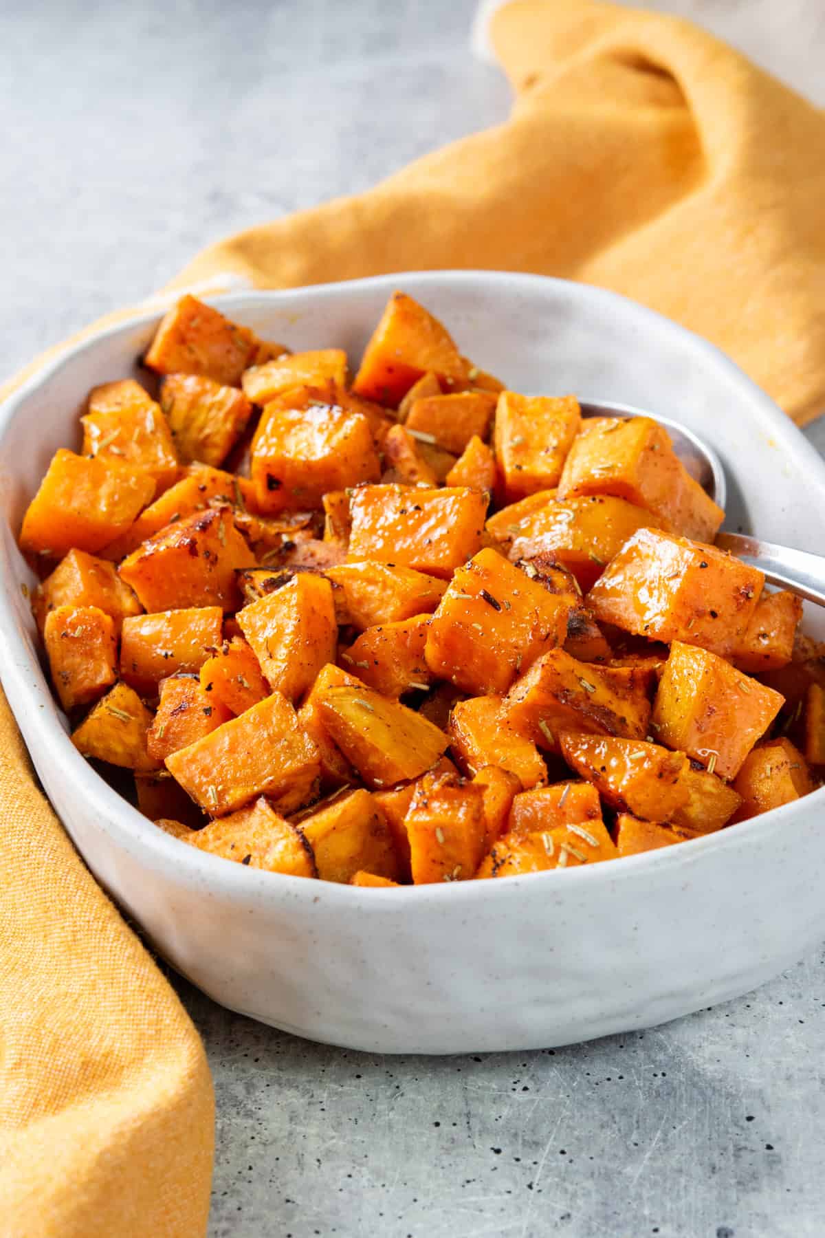 Roasted sweet potatoes in a serving dish. The potatoes are cubed and roasted.
