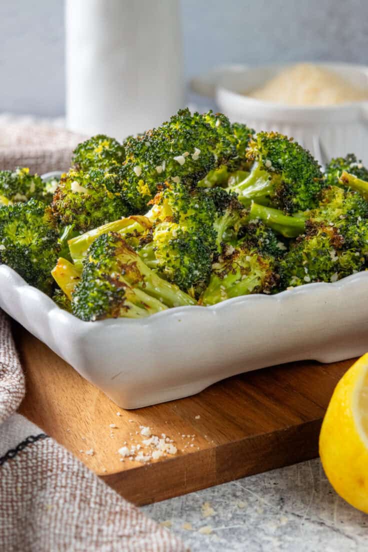 Roasted broccoli with garlic and lemon zest, served in a white ceramic dish.