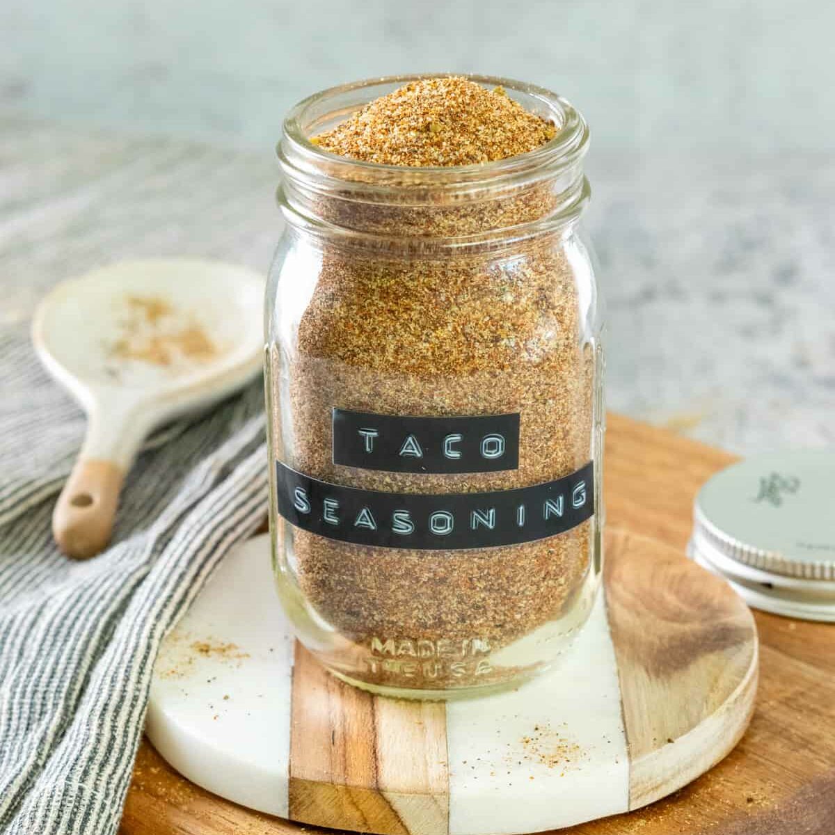 Jar of homemade taco seasoning with a label on the spice jar that says, taco seasoning.