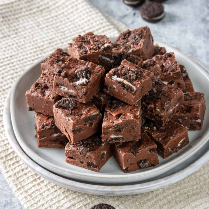 Rich Oreo Fudge piled on a plate with mini Oreos around it.
