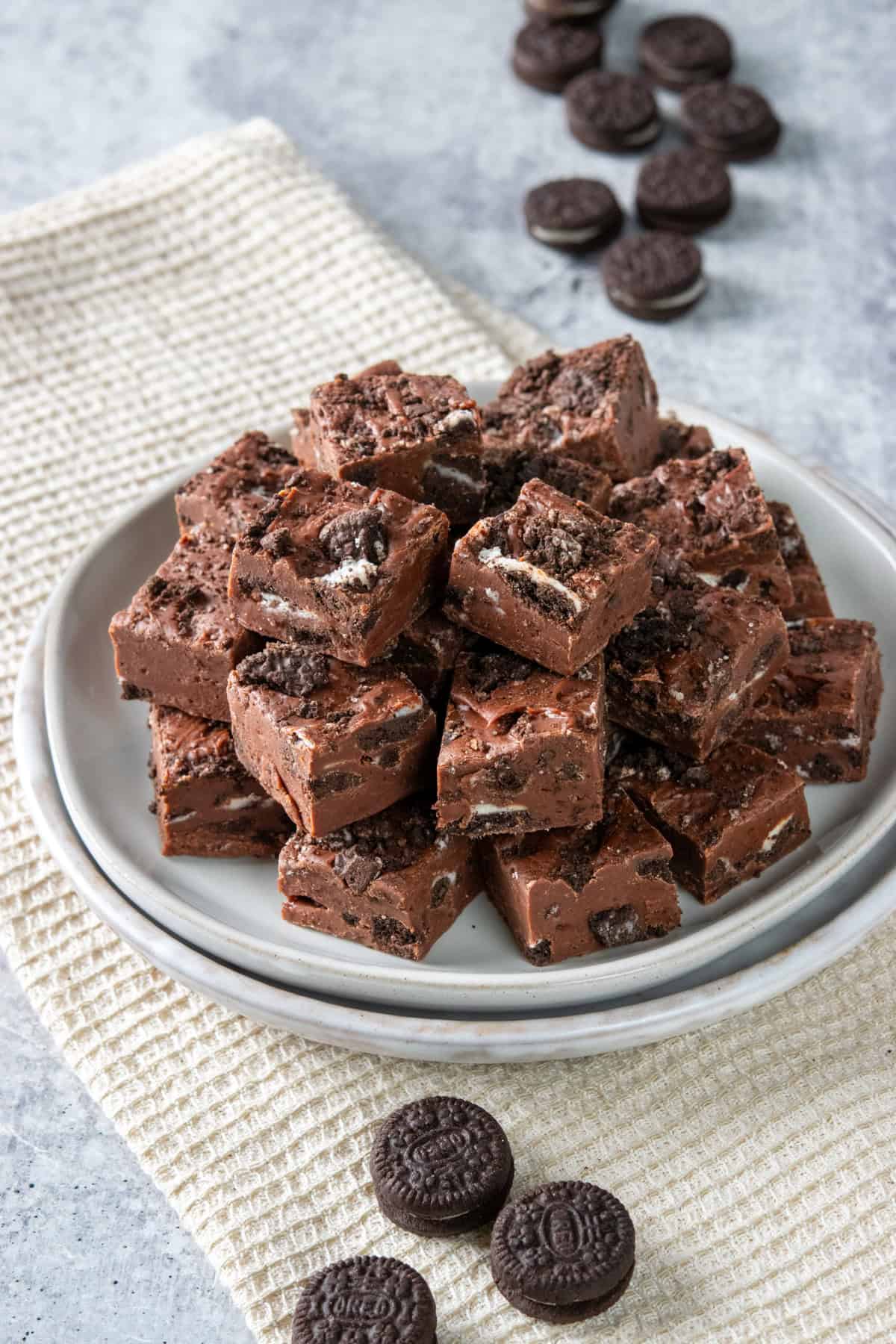 Rich Oreo Fudge piled on a plate with mini Oreos around it.