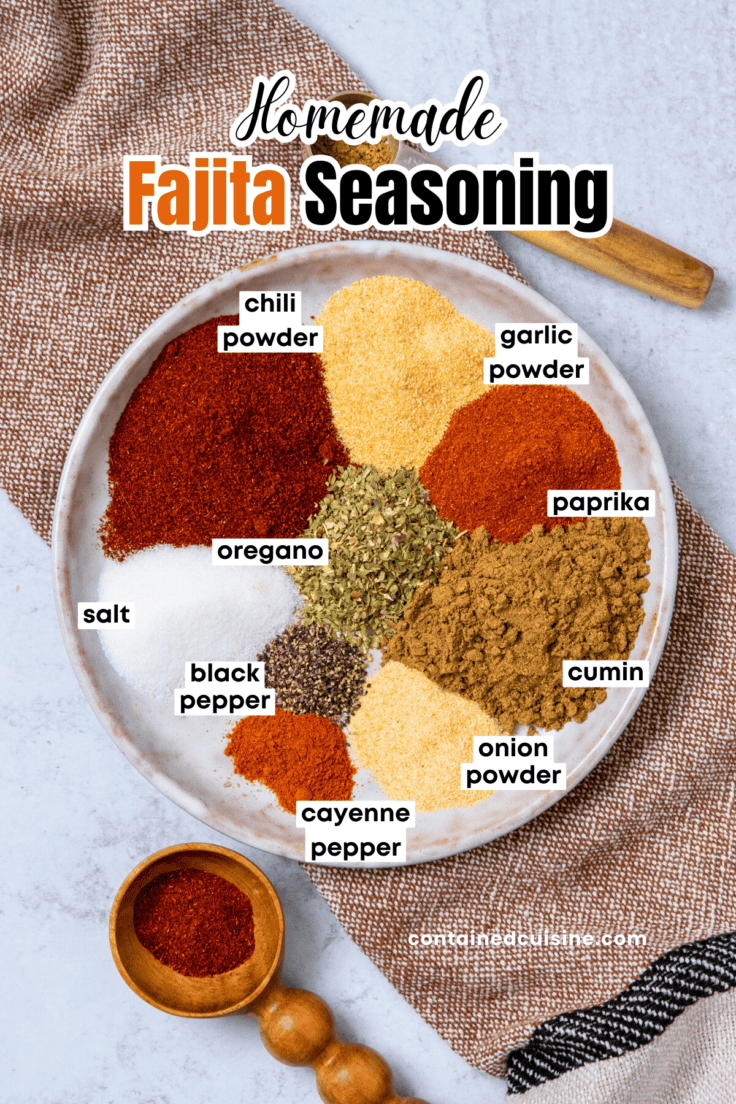 Overhead view of labeled spices for homemade fajita seasoning, including chili powder, cumin, paprika, oregano, garlic powder, onion powder, salt, black pepper, and cayenne.