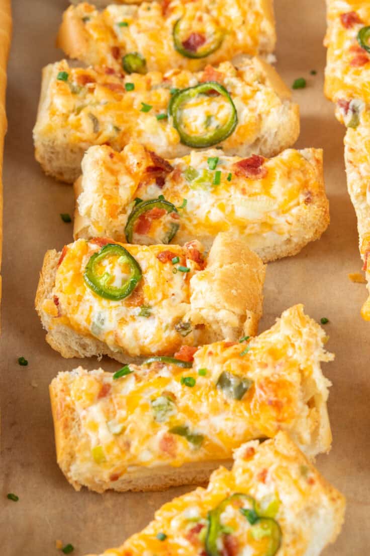 Close-up of sliced jalapeño popper cheese bread with gooey melted cheese, bacon, and jalapeños.
