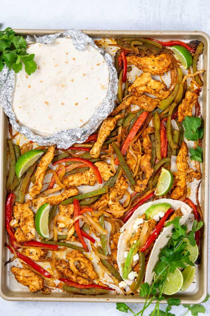 Sheet pan chicken fajitas fresh from the oven with roasted chicken, peppers, onions, lime juice, warm tortillas, and an assembled fajita with toppings.