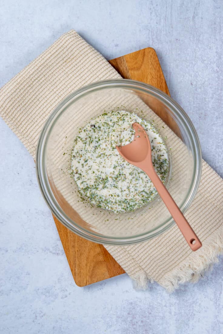Making a panade for baked meatballs by combining bread crumbs and milk.