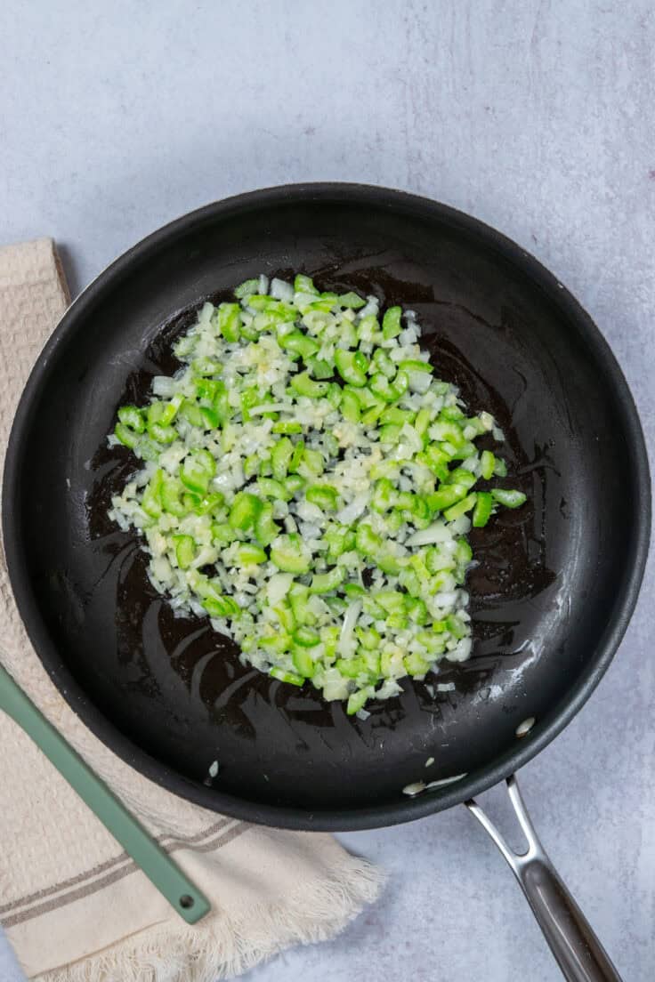 Sauteed onion and celery in skillet for classic tuna casserole recipe.