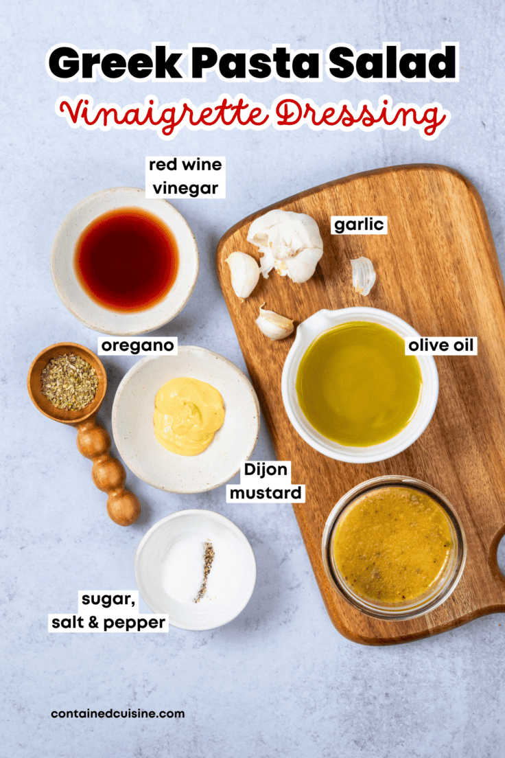 Labeled ingredients for homemade Greek vinaigrette dressing including olive oil, red wine vinegar, garlic, and seasonings.