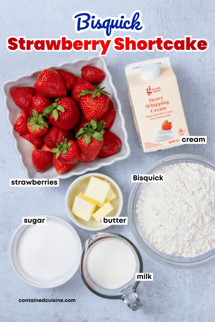 Overhead view of the labeled ingredients needed to make homemade Bisquick strawberry shortcake, including strawberries, Bisquick mix, butter, sugar, milk, and whipped cream.
