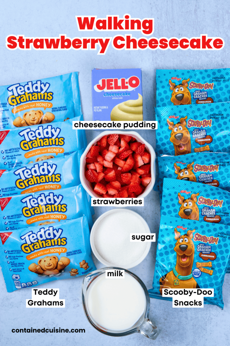Overhead view of the ingredients for walking strawberry cheesecake, including Teddy Grahams, Scooby-Doo cinnamon graham crackers, instant cheesecake pudding, milk, strawberries, and sugar.