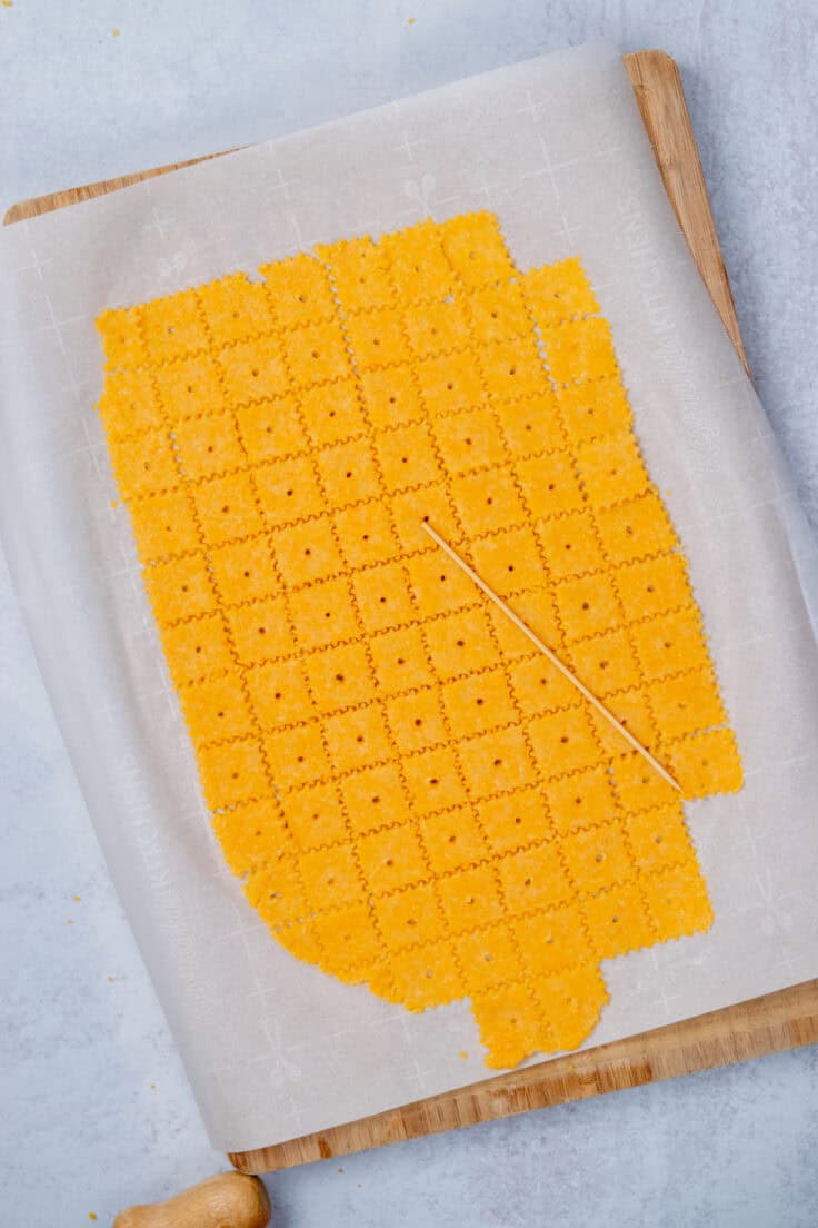 Homemade Cheez-Its with holes pressed into the centers and sprinkled with flaky sea salt before baking.